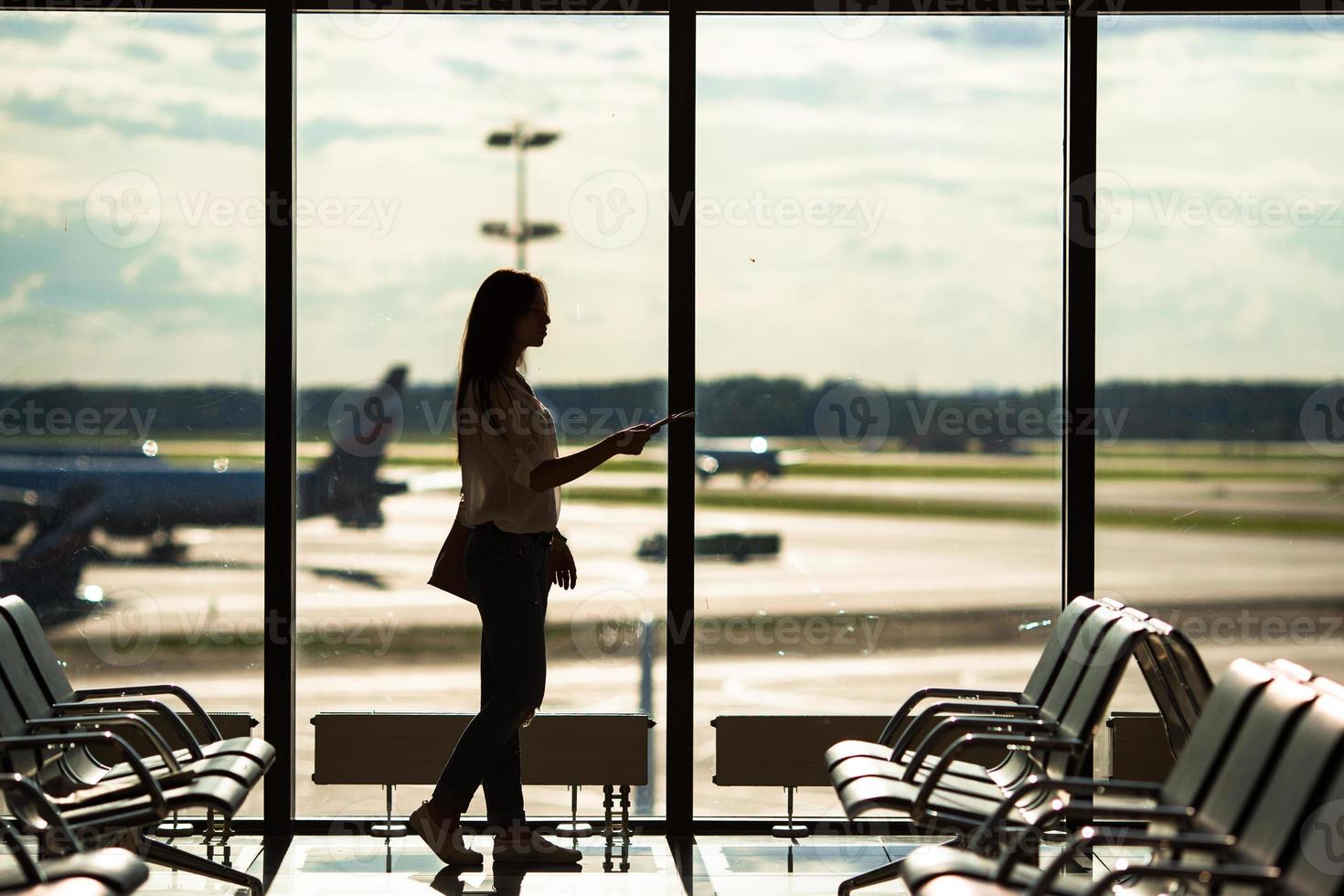 silhueta de passageiro de avião em um saguão de aeroporto esperando aeronaves de voo foto