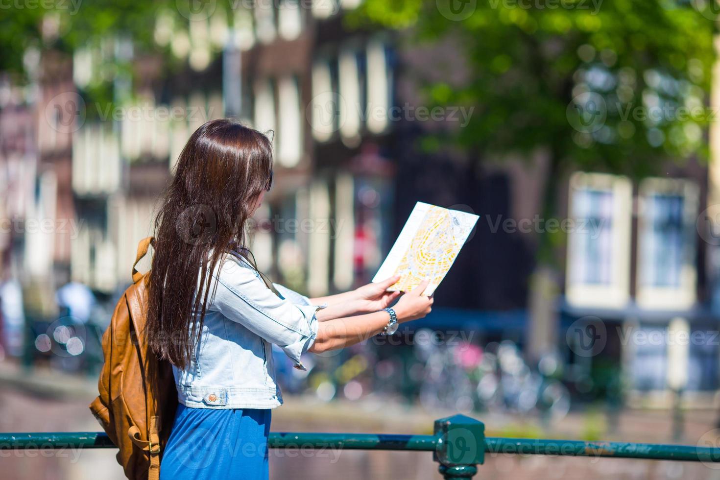 mulher jovem feliz com um mapa da cidade e mochila na europa foto