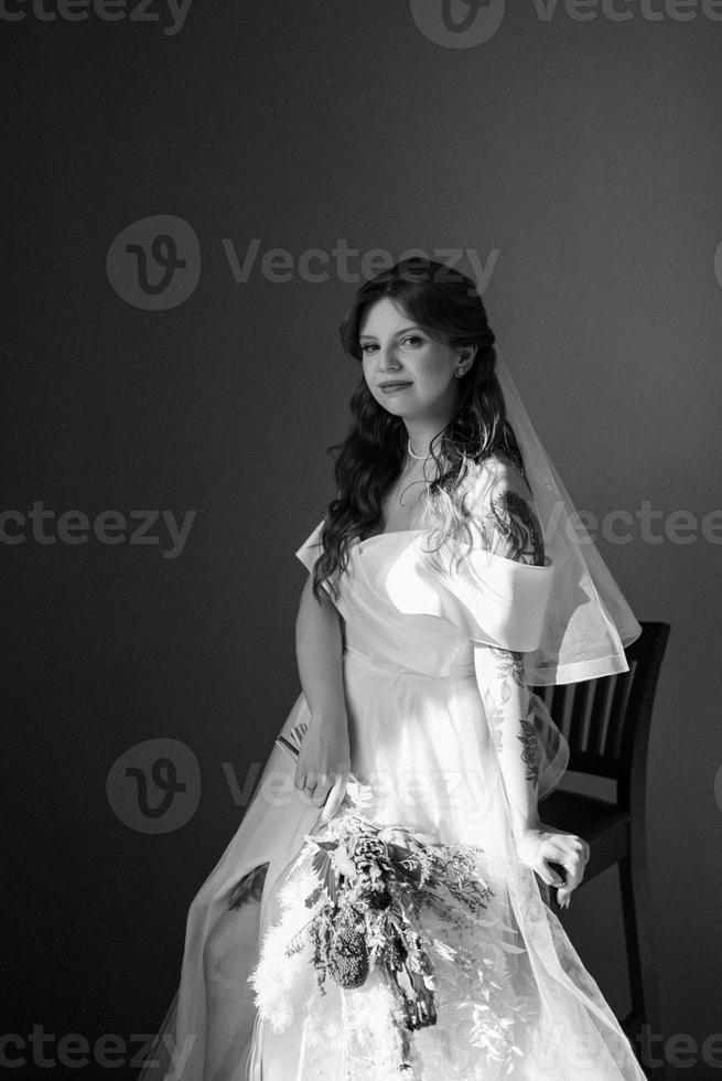 retrato de uma noiva com cabelo ruivo em um vestido de noiva branco foto