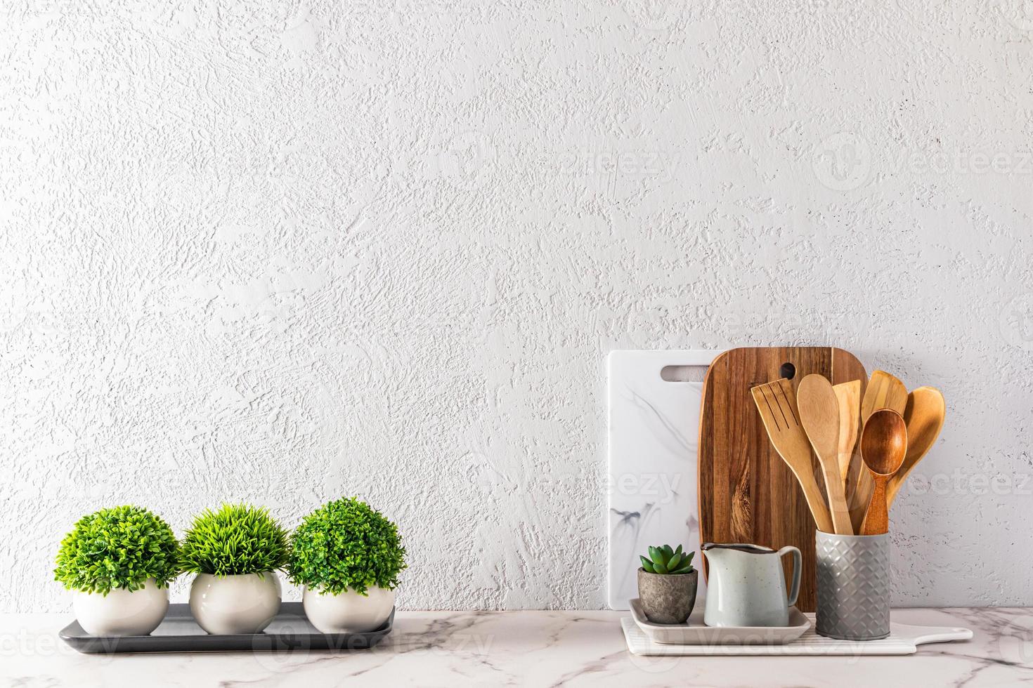 fundo de cozinha moderna com utensílios ecológicos e plantas em vasos de cerâmica em uma bancada de mármore branco. uma cópia do espaço. foto