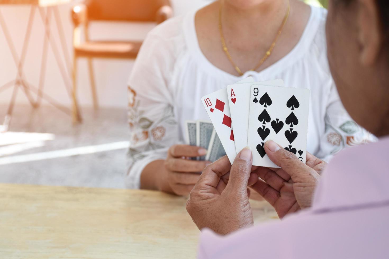 jogo de cartas de idosos em casa em seus tempos livres, recreação e felicidade do conceito de idosos. foto