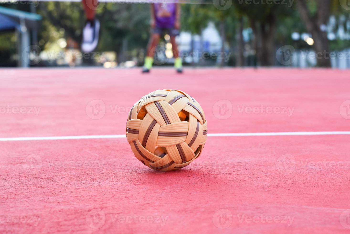 bola sepak takraw no piso vermelho da quadra ao ar livre, fundo desfocado, atividade recreativa e esportes ao ar livre no conceito de países do sudeste asiático. foto