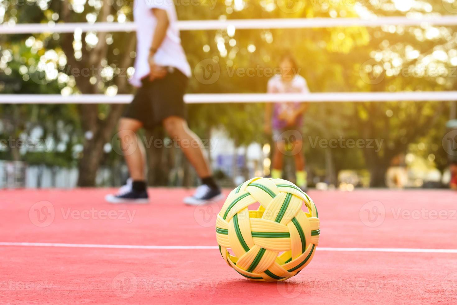 bola sepak takraw no piso vermelho da quadra ao ar livre, fundo desfocado, atividade recreativa e esportes ao ar livre no conceito de países do sudeste asiático. foto
