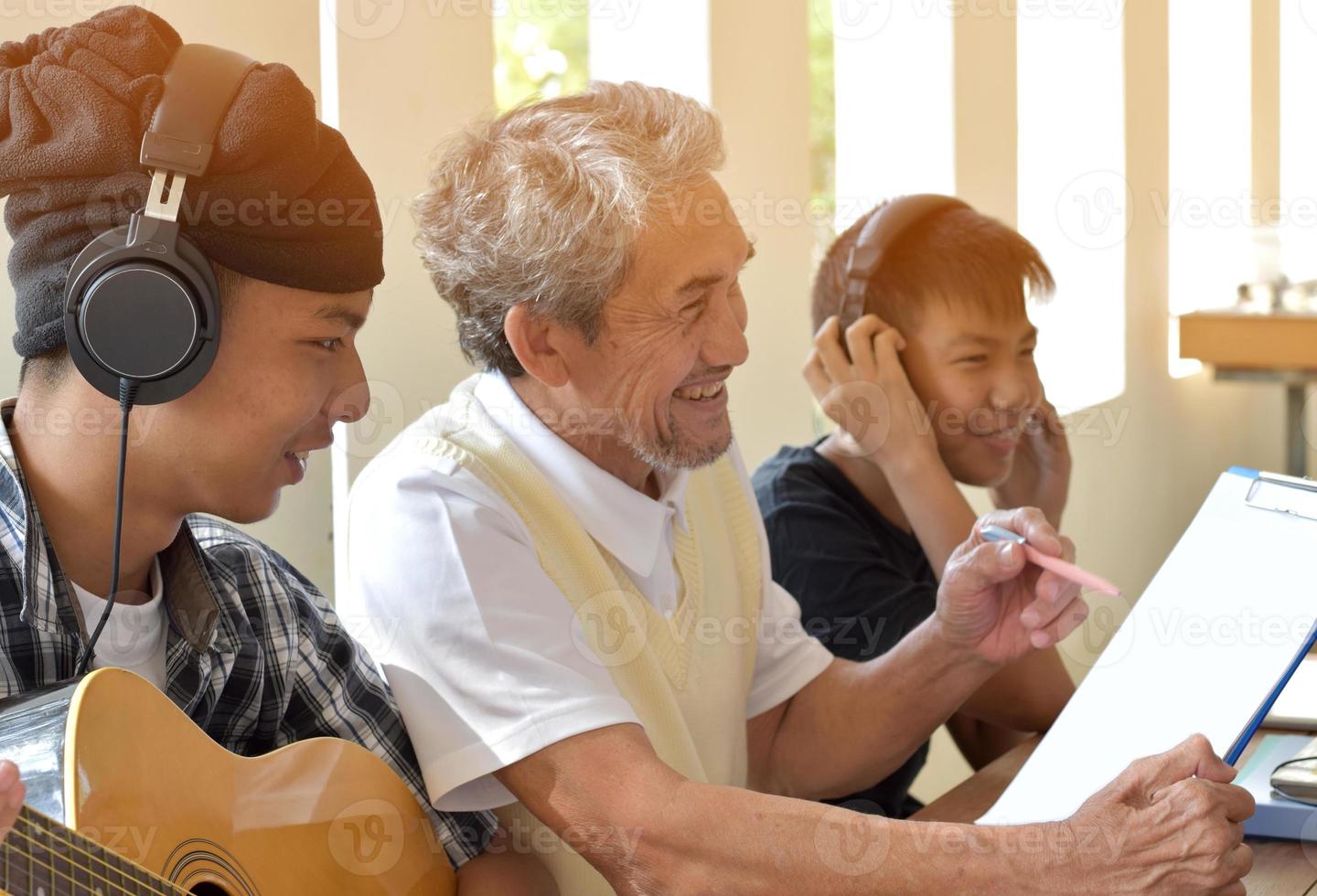 meninos asiáticos aprendendo e tendo aulas de música com um professor idoso ao lado da varanda da sala de música, foco suave e seletivo no primeiro menino, conceito para diversão de adultos e jovens. foto