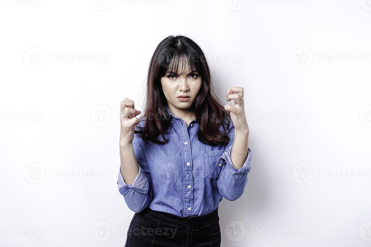 um retrato de uma mulher asiática vestindo uma camisa azul isolada por um fundo branco parece deprimido foto