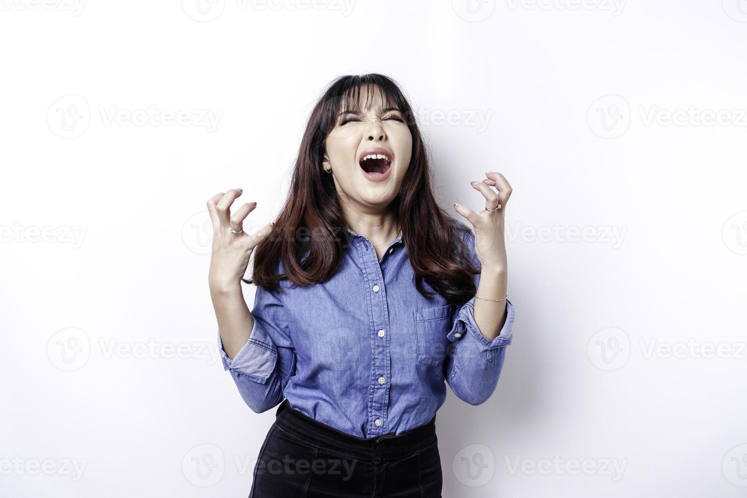 um retrato de uma mulher asiática vestindo uma camisa azul isolada por um fundo branco parece deprimido foto