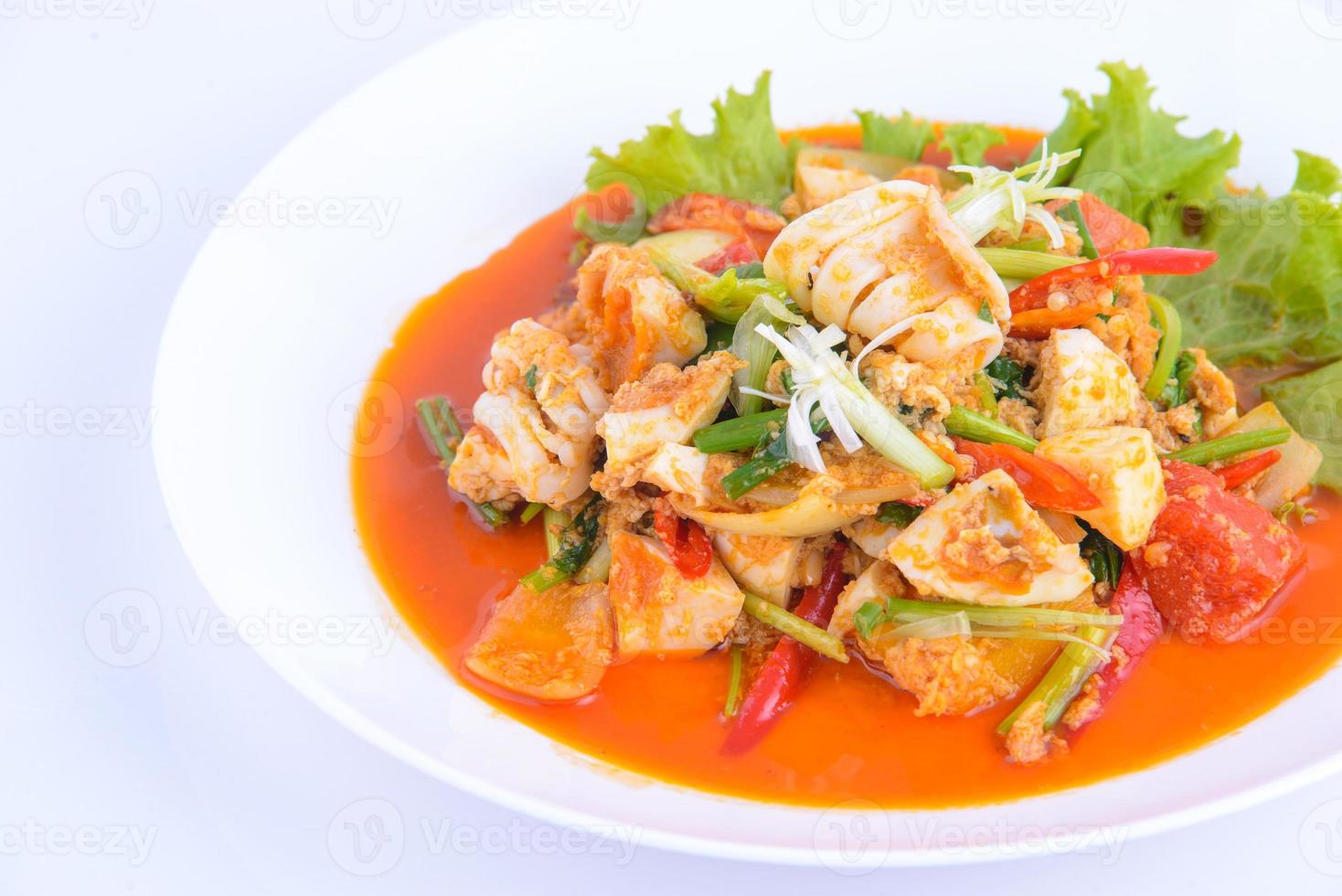 comida tailandesa favorita. mexa lulas fritas com curry no prato branco. foto