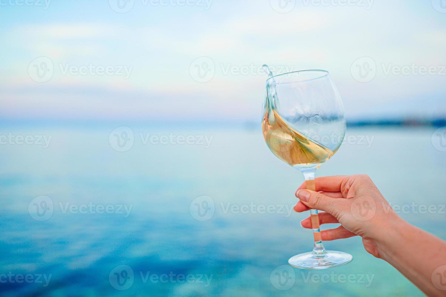 copo de vinho branco na praia tropical foto
