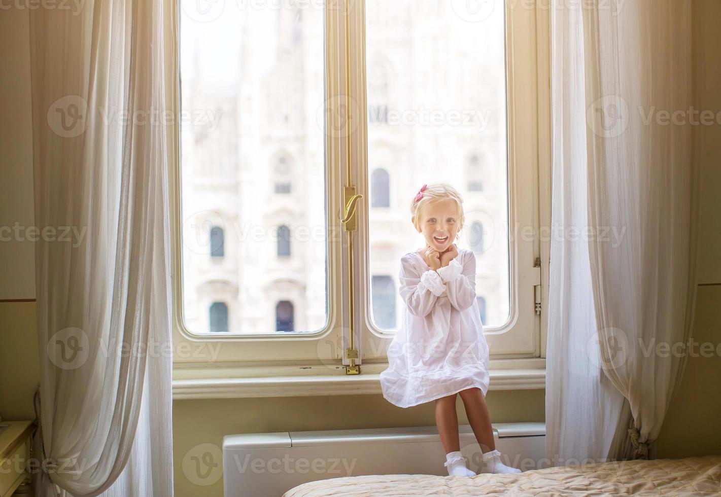 adorável menina olhando pela janela no duomo, milão, itália foto