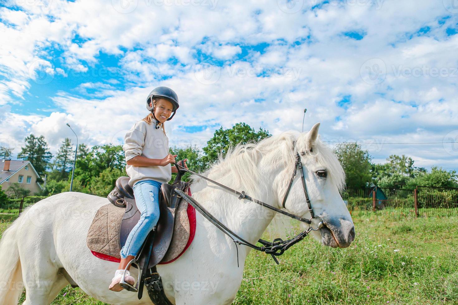 menina montando um cavalo branco na natureza foto