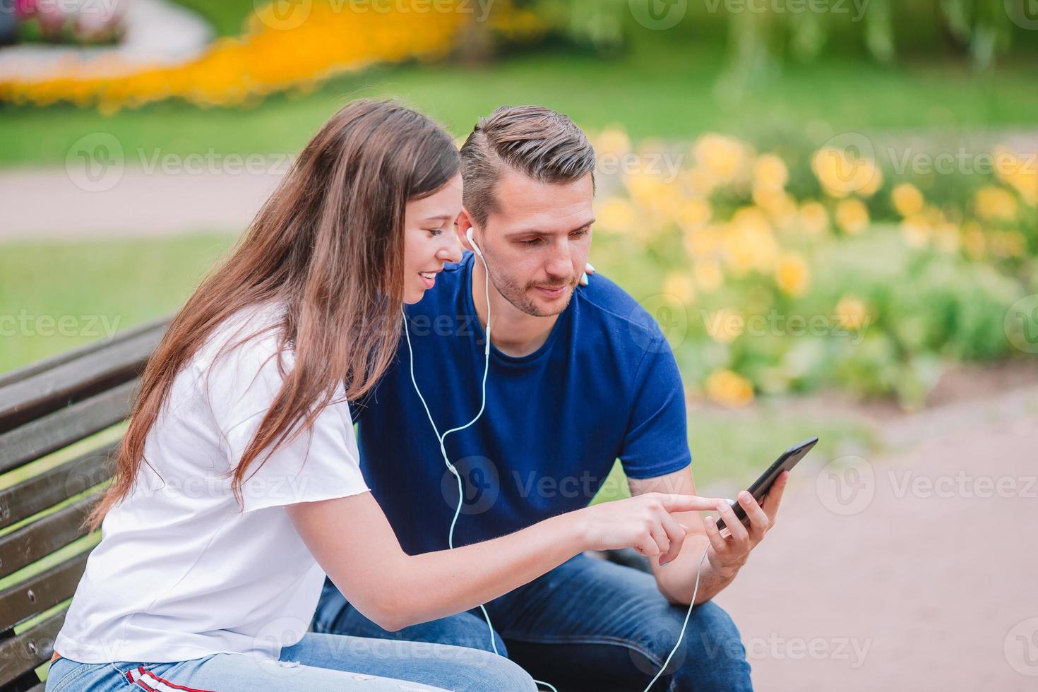 família jovem relaxada no banco do parque foto