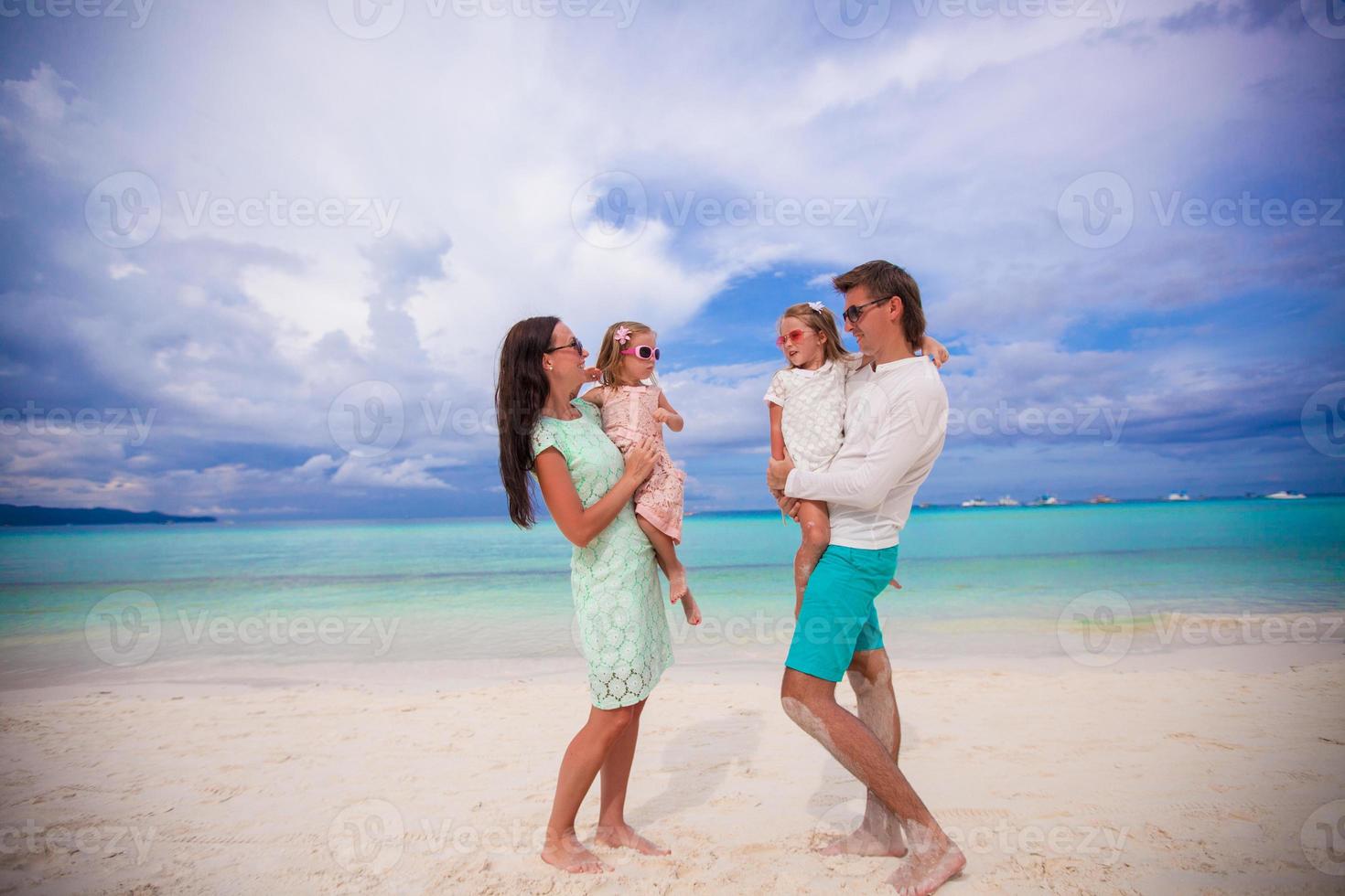 jovem linda família com dois filhos se olhando em férias tropicais foto