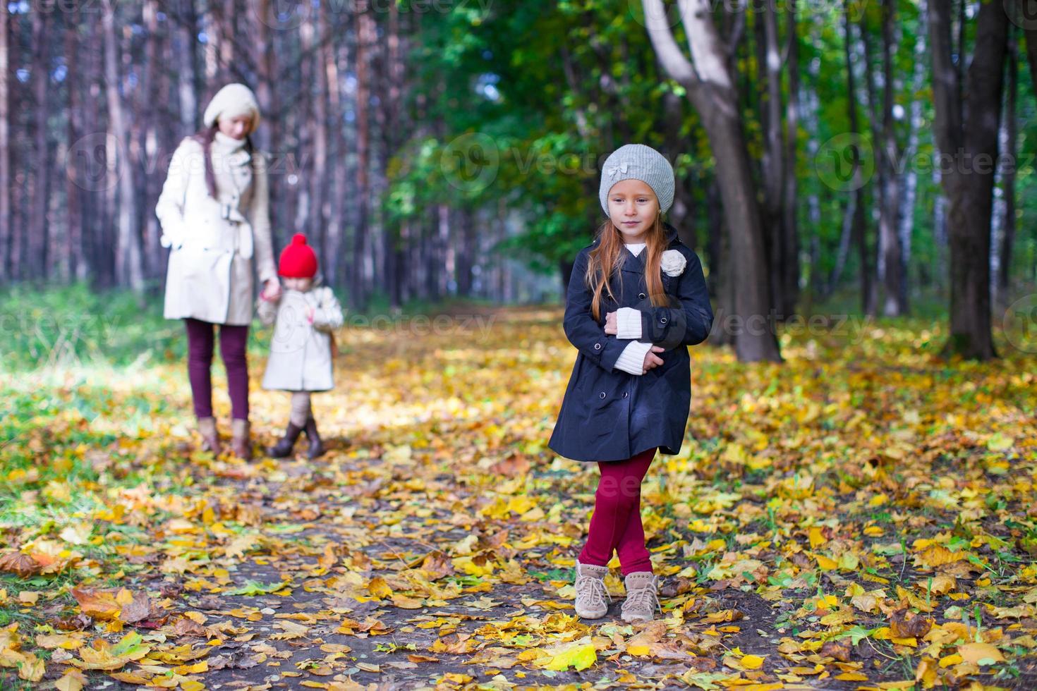 jovem mãe e sua adorável filha caminhando na floresta amarela de outono em um dia quente e ensolarado foto