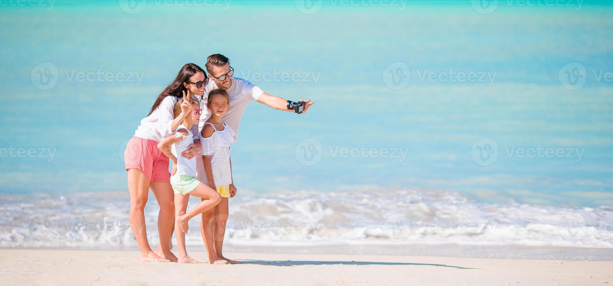 homem tirando uma foto de sua família na praia