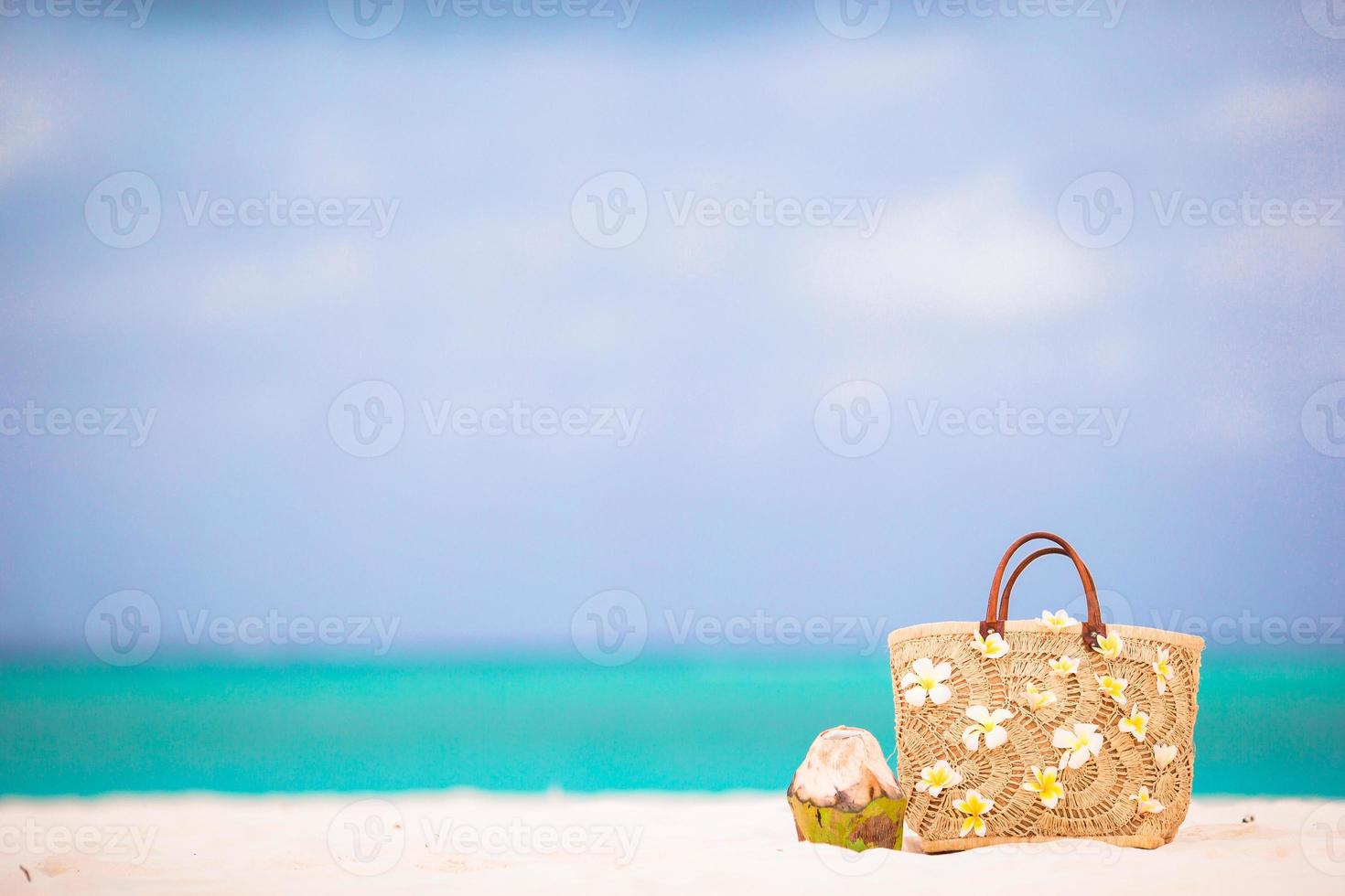 closeup linda bolsa com flores frangipani e coco na praia branca foto