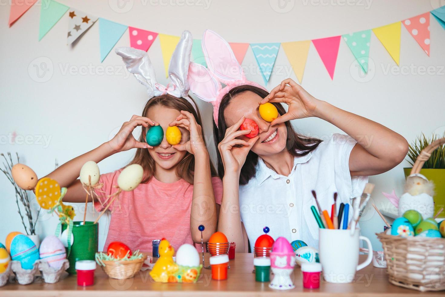 mãe e sua filha pintando ovos. família feliz se preparando para a páscoa. foto