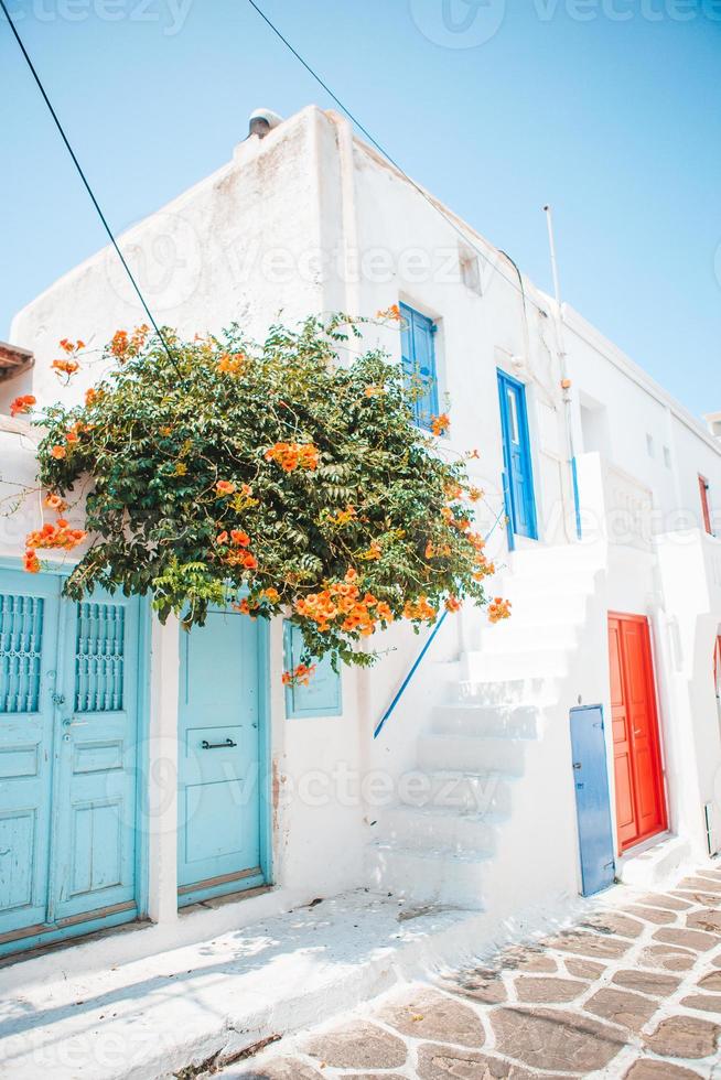 as ruas estreitas da ilha com varandas azuis, escadas e flores na Grécia. foto