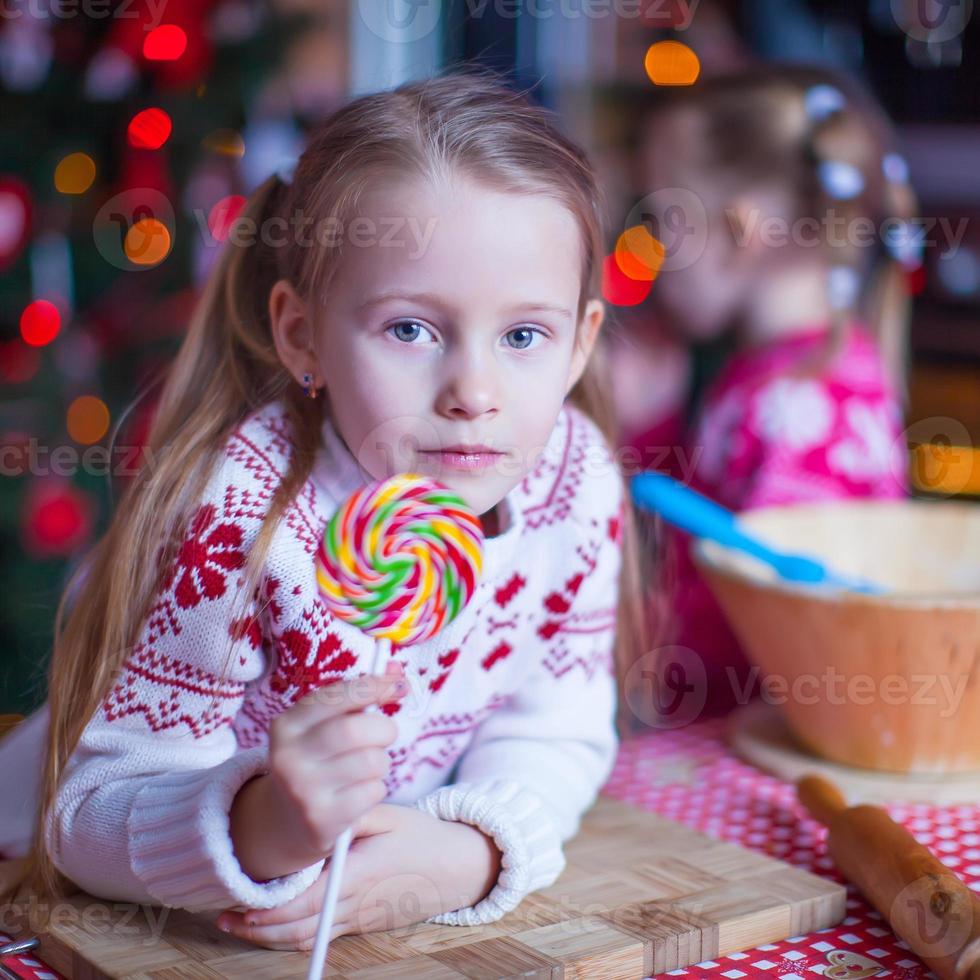 menina com doces preparando bolos de natal foto
