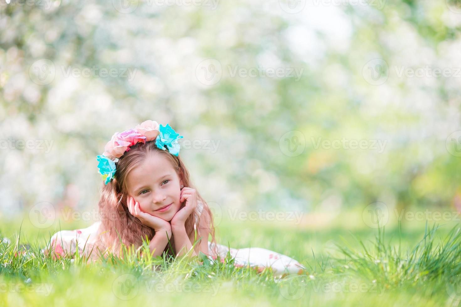 menina adorável no jardim de macieiras florescendo na primavera foto