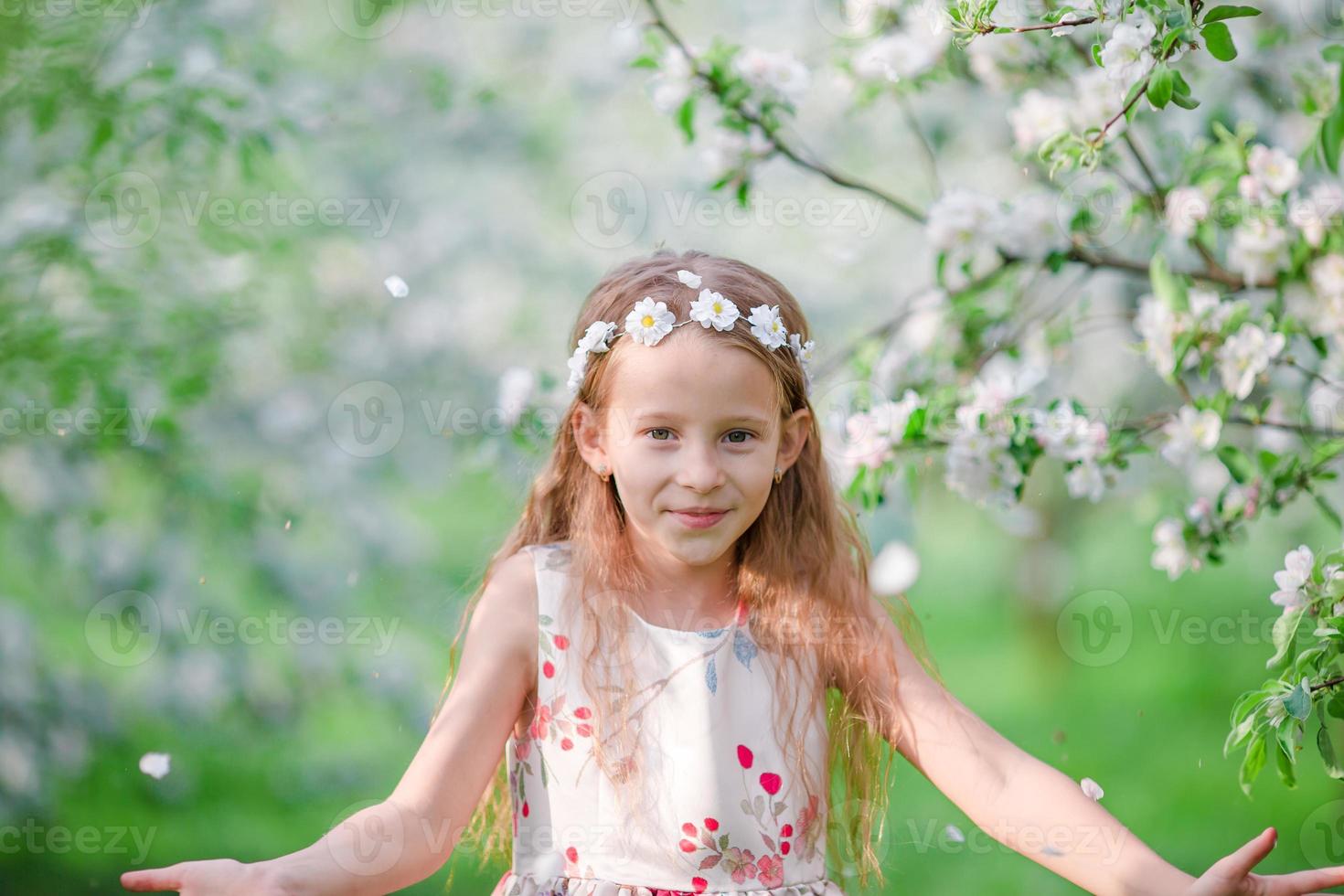 menina adorável no jardim de macieiras florescendo na primavera foto