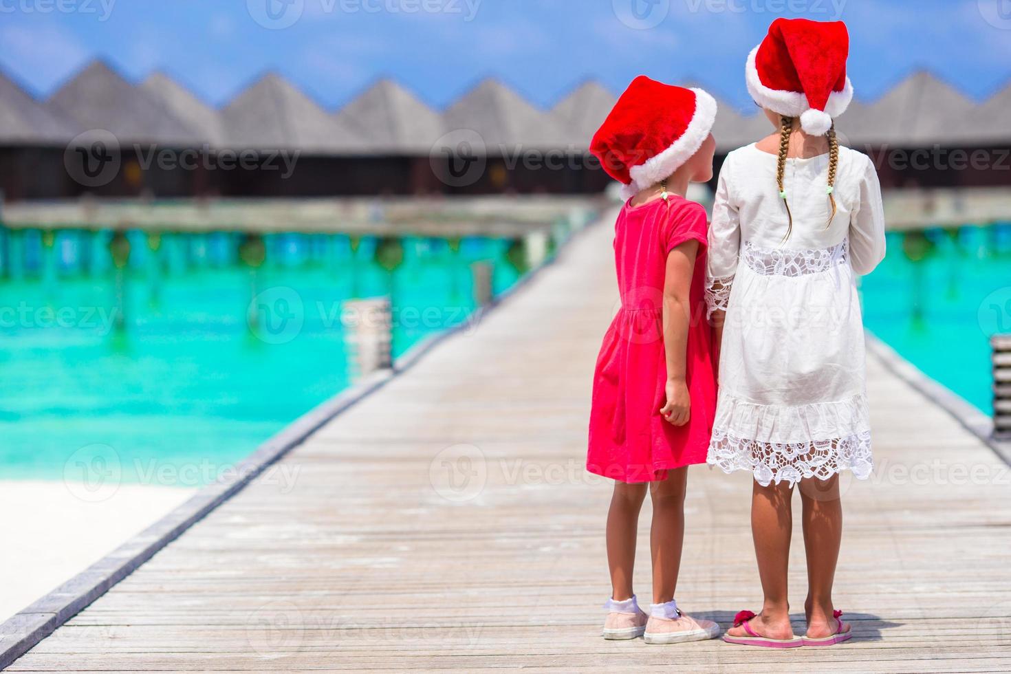 meninas de turistas com mala grande na praia tropical branca. conceito de viagem. foto