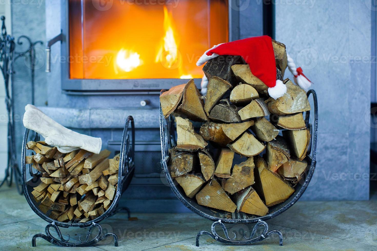 lenha com chapéu de papai noel na casa perto de uma lareira foto