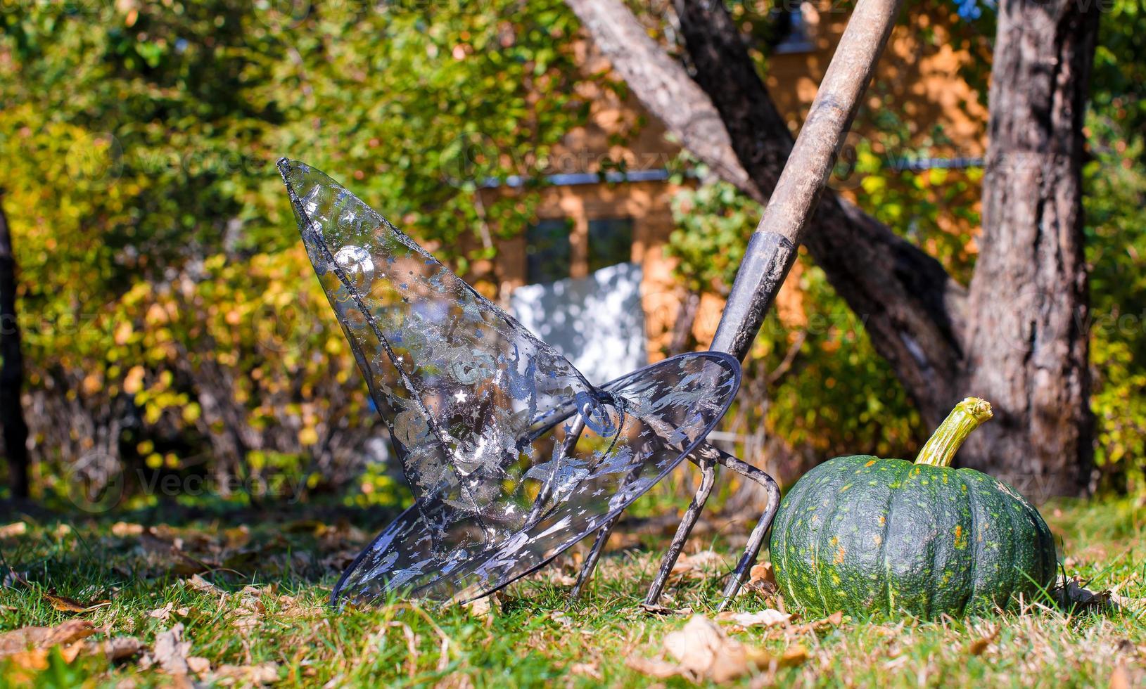 vista das abóboras de halloween, chapéu de bruxa e ancinho ao ar livre foto