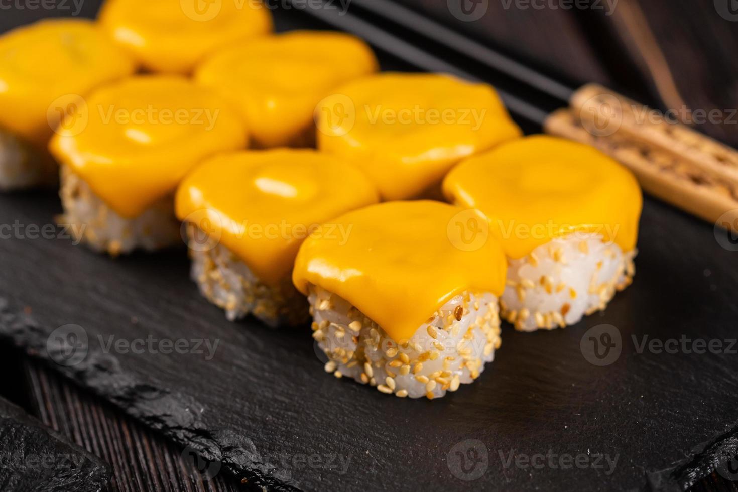 rolo de sushi com queijo com close-up de pauzinhos - conceito de comida japonesa asiática foto