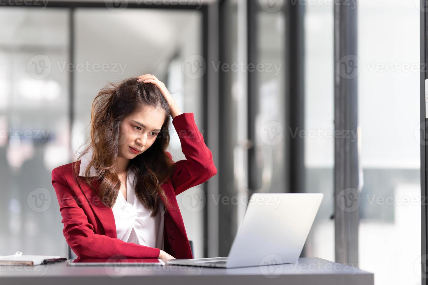 mulher asiática pensando muito preocupada com a solução de problemas on-line olhando para a tela do laptop, preocupada empresária asiática séria focada em resolver tarefa difícil de computador de trabalho foto