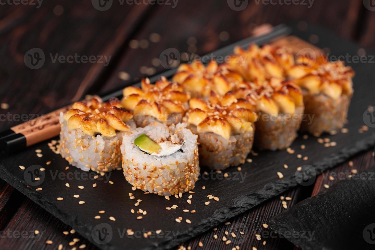 rolo de sushi com enguia defumada com close-up de abacate e queijo. tradicional delicioso conjunto de rolo de sushi fresco. cardápio de sushi. restaurante de cozinha japonesa. comida asiática foto