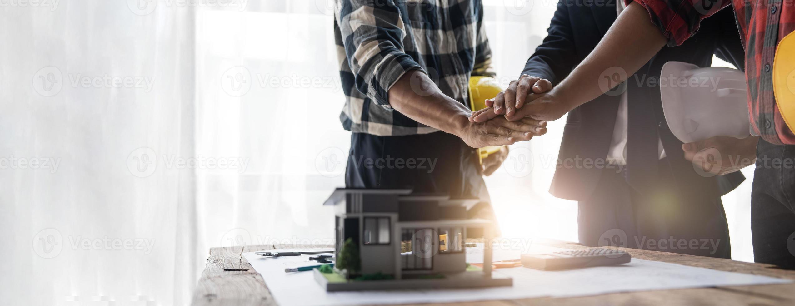 grupo de técnicos de engenharia industrial, trabalhadores masculinos e femininos de várias nacionalidades unem forças para o sucesso, trabalho em equipe e unidade foto