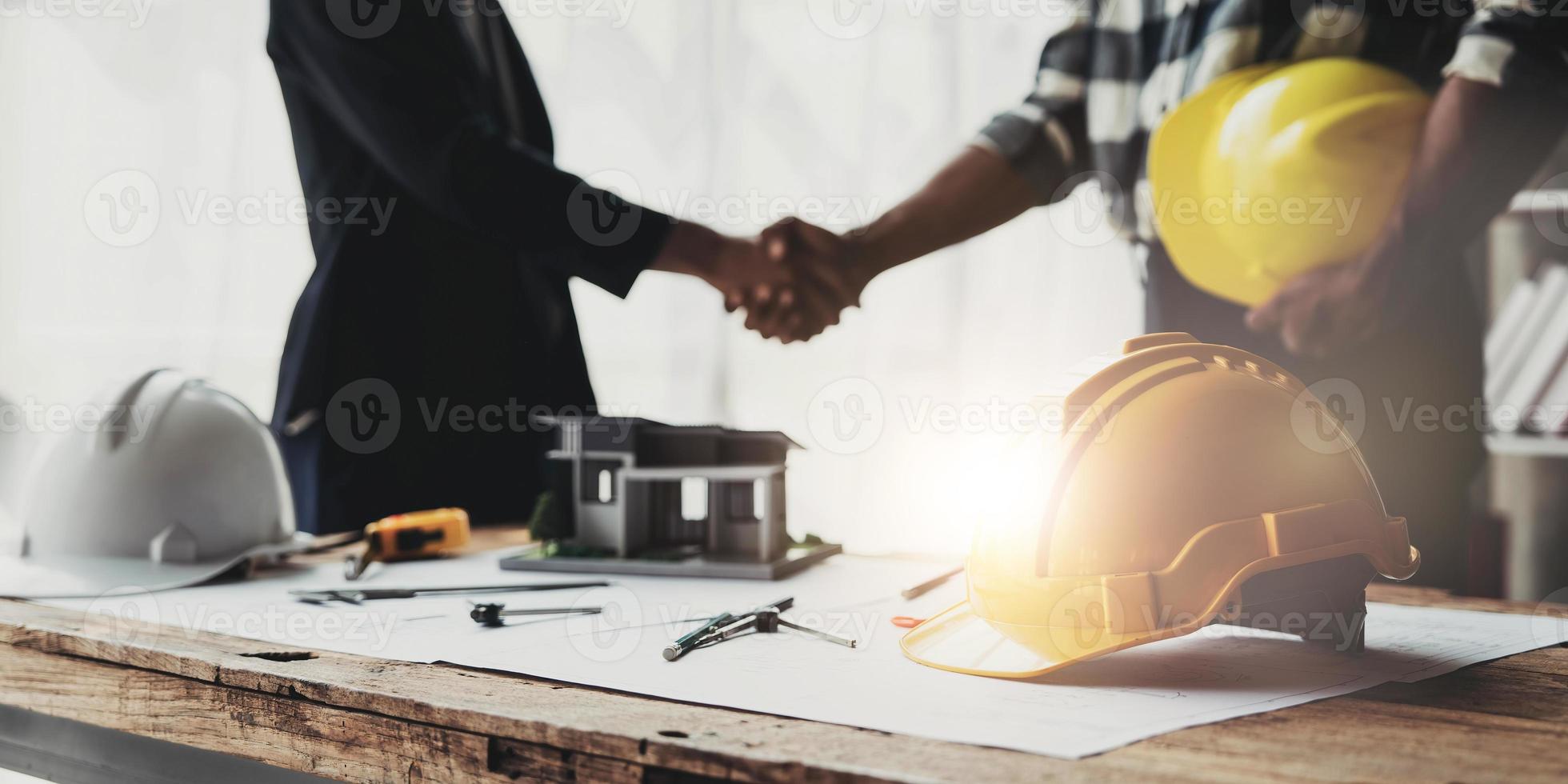 equipes de engenheiros civis reunidas trabalhando juntas usam capacetes de trabalhadores no canteiro de obras na cidade moderna. trabalho em equipe do engenheiro do gerente de projeto da indústria do capataz. equipe profissional da indústria asiática foto