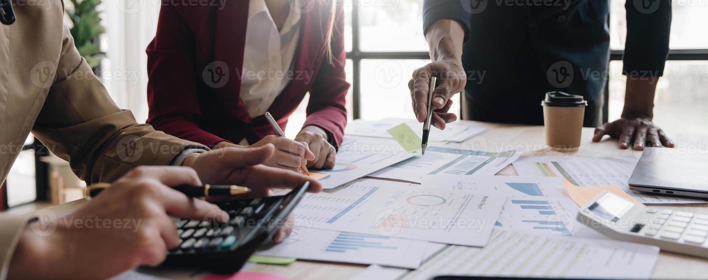 pessoas de negócios reunidas usando computador portátil, calculadora, notebook, papel gráfico do mercado de ações para planos de análise para melhorar a qualidade no próximo mês. conceito corporativo de discussão de conferência foto