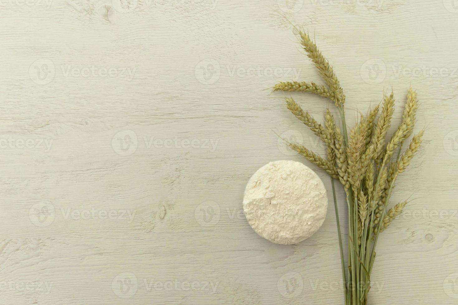 monte espiga de trigo e farinha na mesa de madeira branca. foto