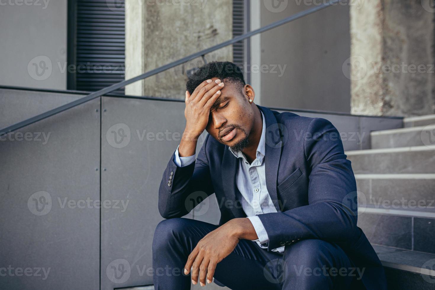 empresário africano sentado frustrado nas escadas deprimido pelos resultados de seu trabalho foto