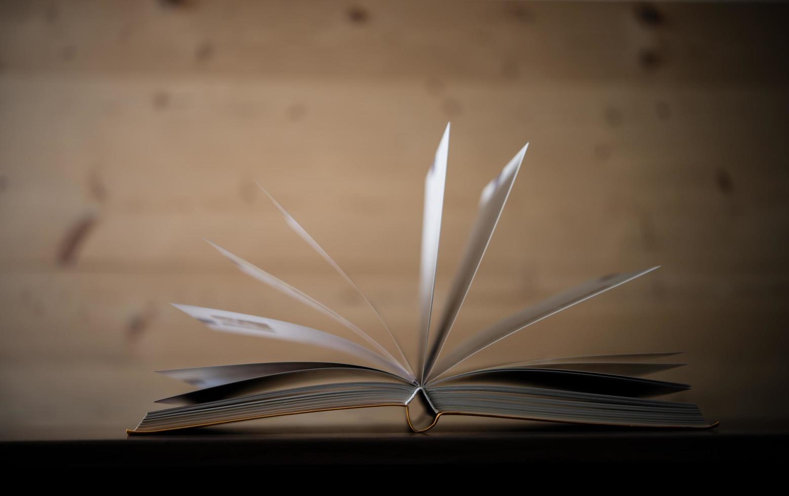 close-up de um livro aberto em uma mesa de madeira foto