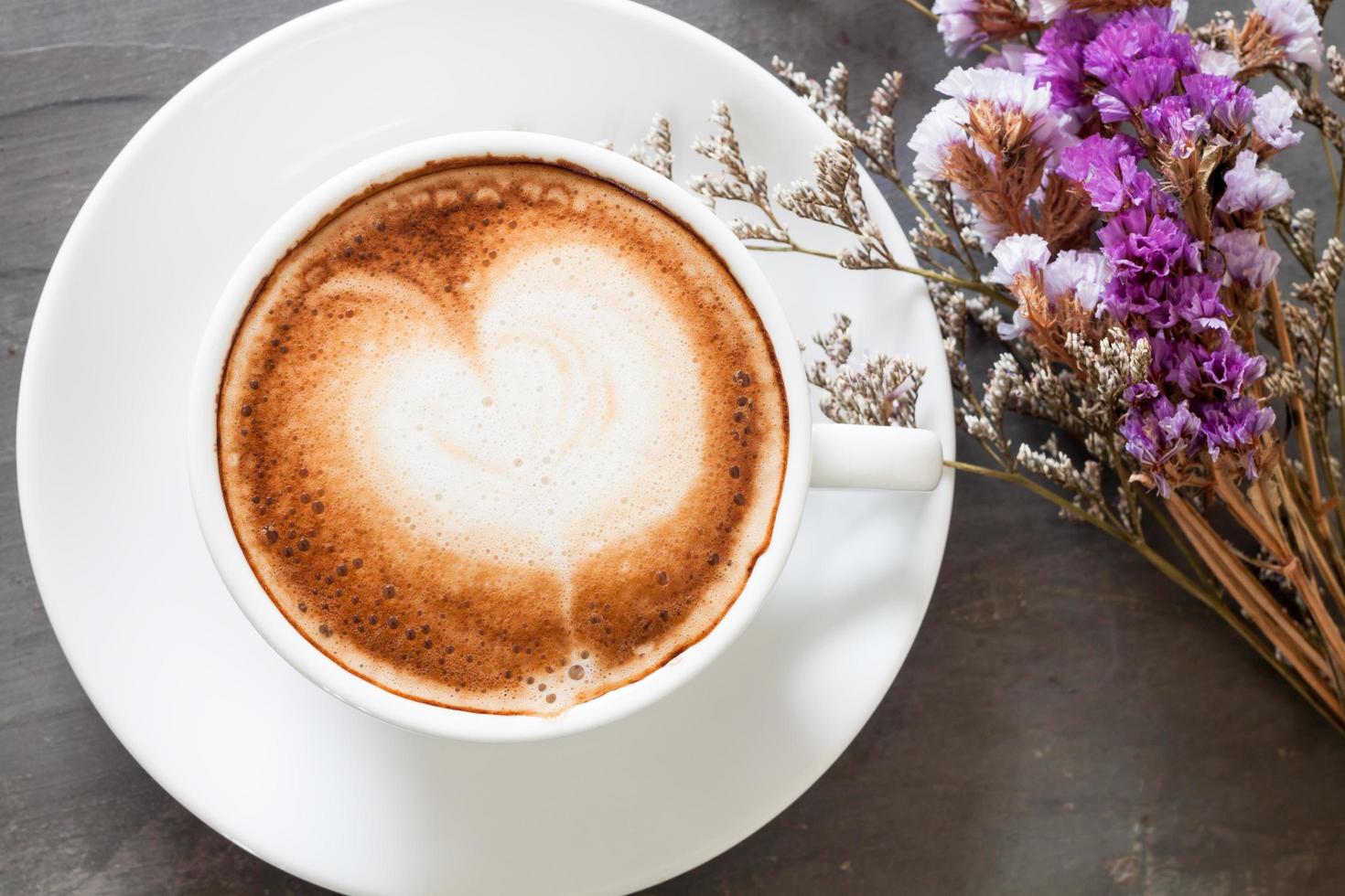 café com leite e flores em um fundo cinza foto