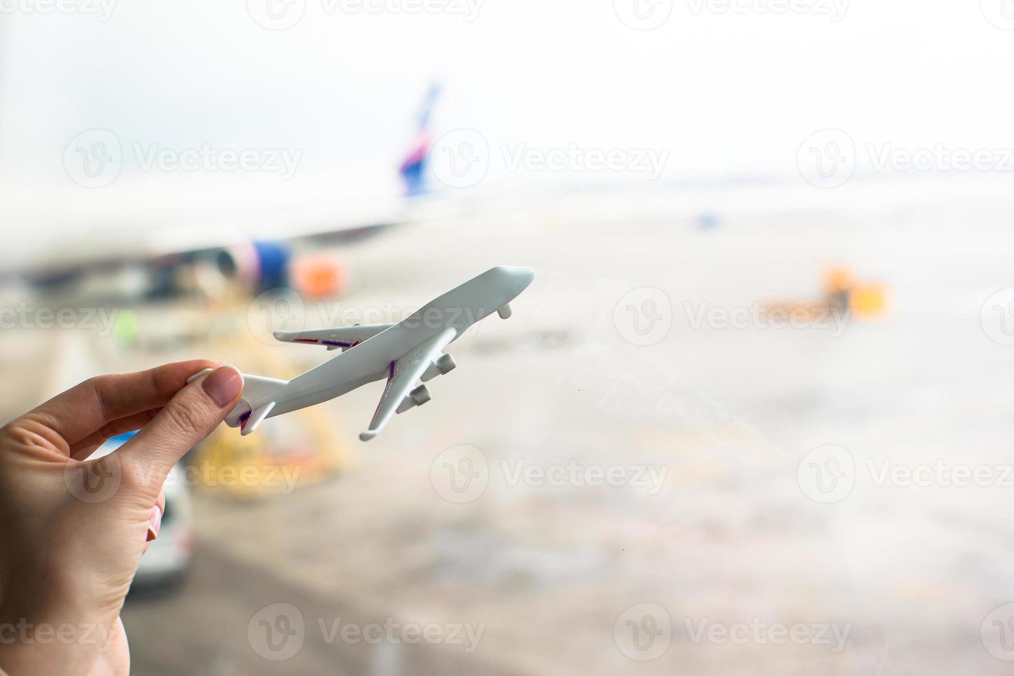 fechar a mão segurando um modelo de avião no aeroporto foto