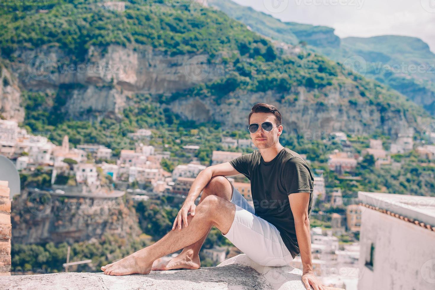 férias de verão na Itália. jovem na vila de positano ao fundo, costa amalfitana, itália foto