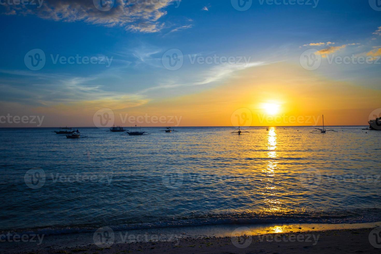 lindo pôr do sol colorido com veleiro no horizonte na ilha de boracay foto