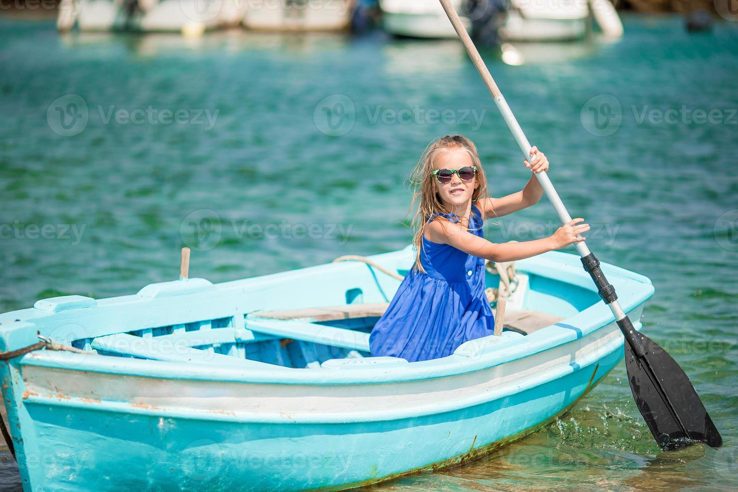 menina no barco azul na baía do mar na grécia foto