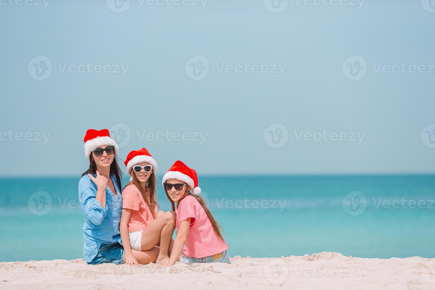 adoráveis meninas e jovem mãe na praia tropical branca foto