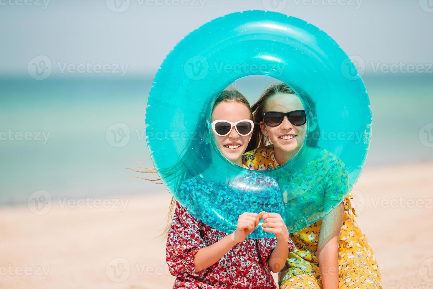 garotinhas engraçadas felizes se divertem muito na praia tropical brincando juntas. foto