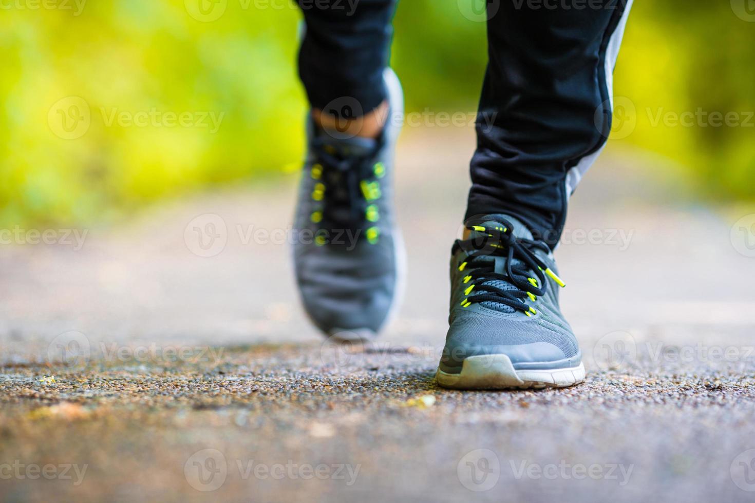 close-up no sapato dos pés do homem corredor atleta correndo na estrada foto