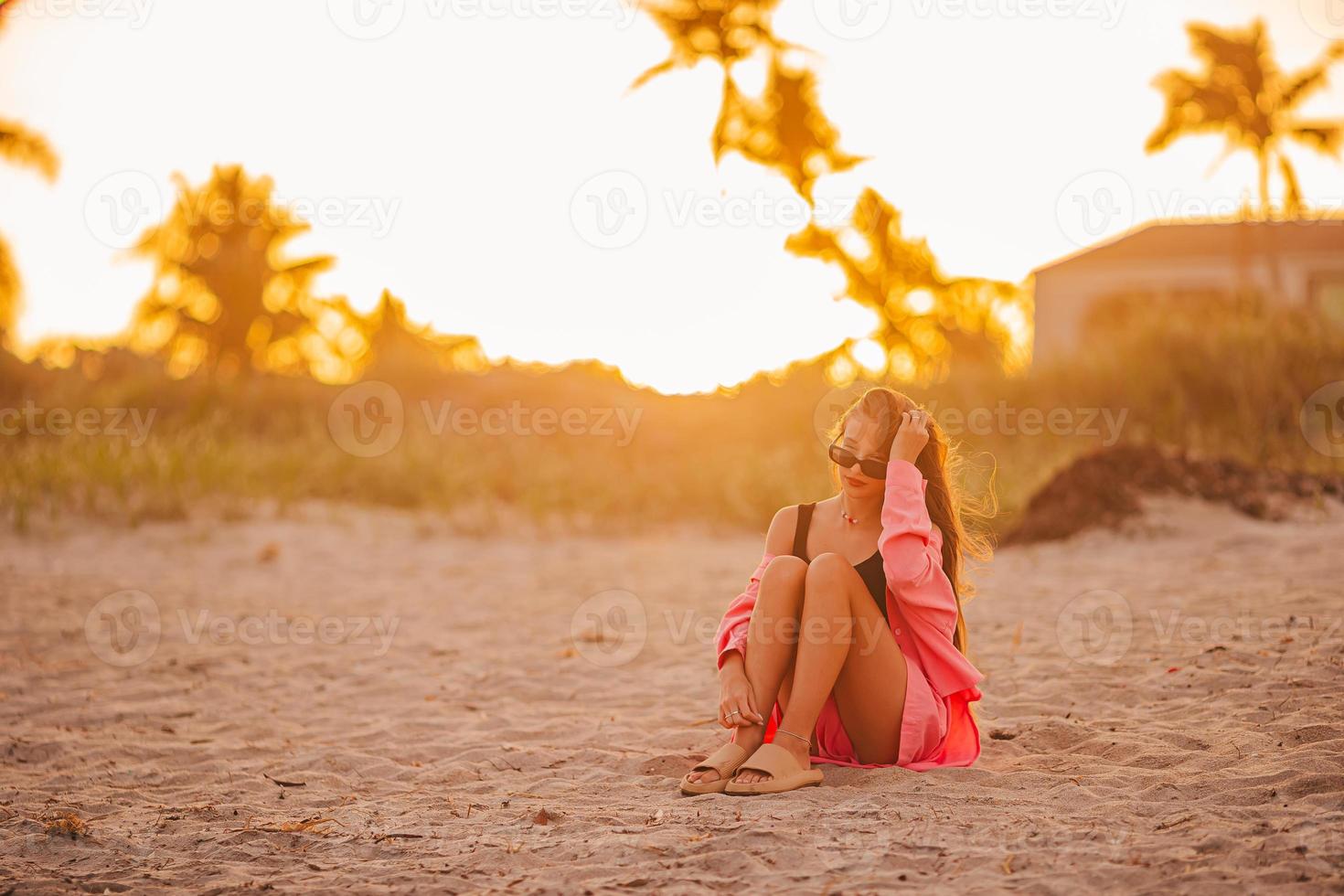 linda garota adolescente bonita na praia tropical ao pôr do sol foto