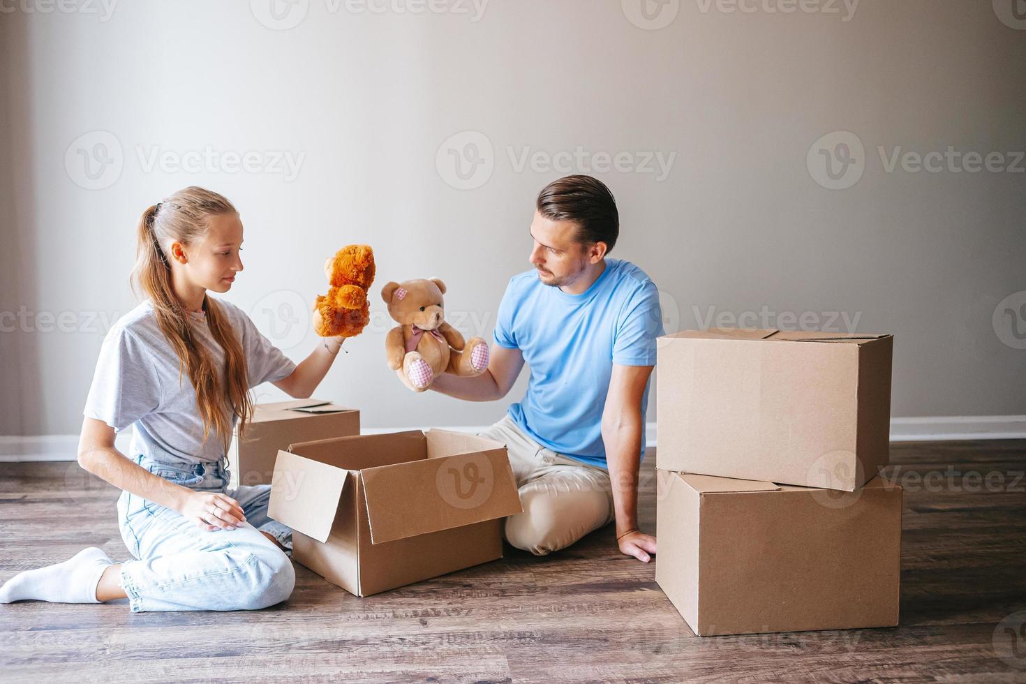 família do pai e sua filha adolescente se divertem em sua nova casa com caixas de papelão. a família aproveita o dia da mudança foto