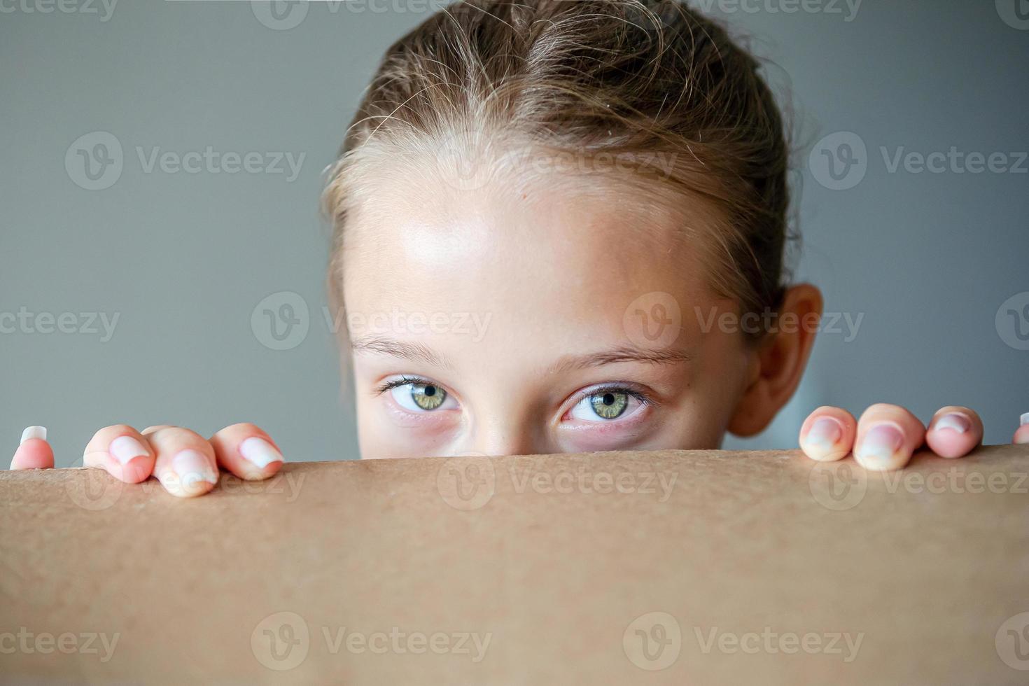 garota feliz com lindos olhos verdes em casa nova com caixa de papelão foto