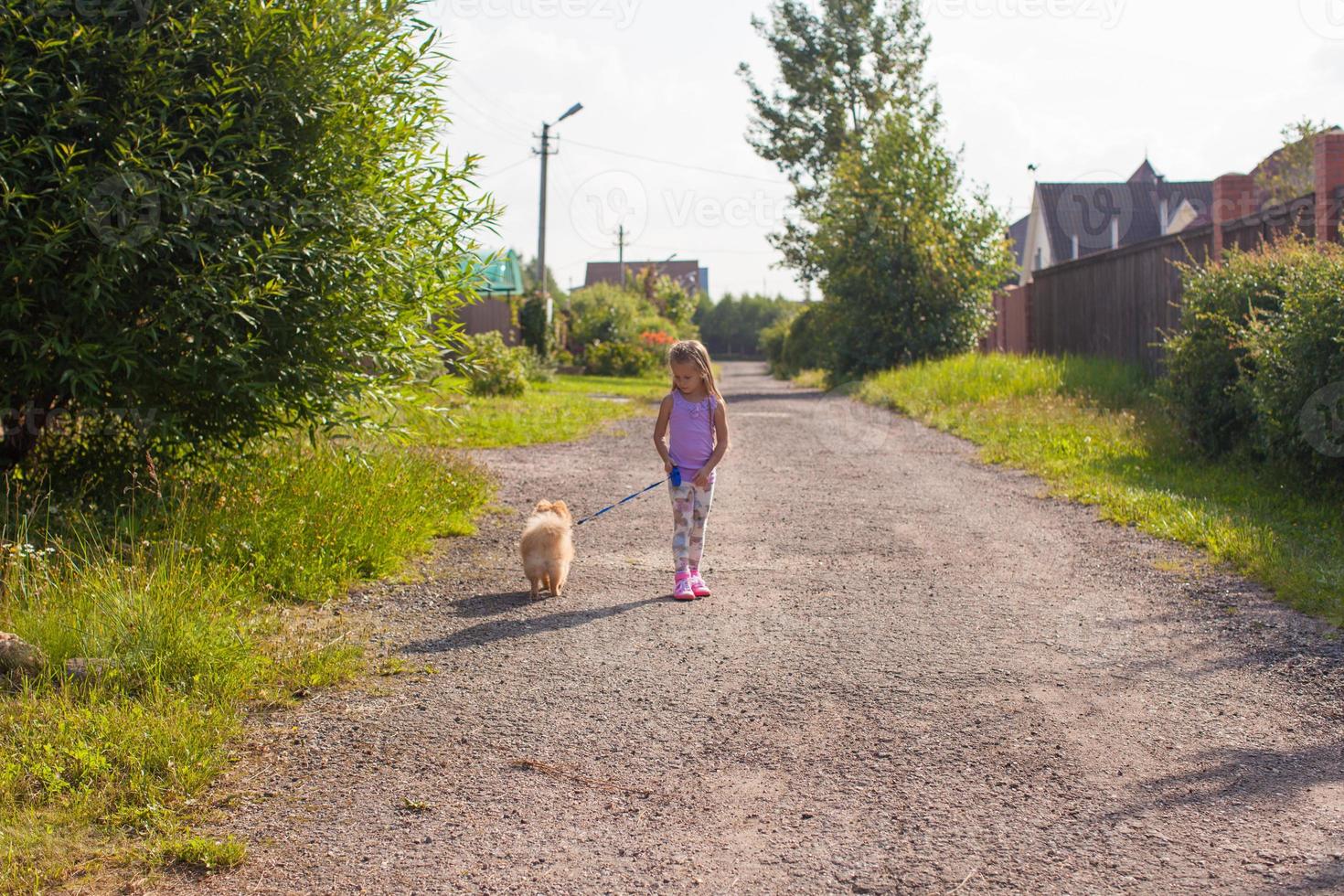 menina andando com seu cachorro na coleira foto