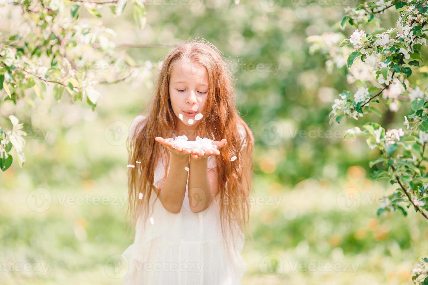 menina adorável no jardim de maçã florescendo em lindo dia de primavera foto