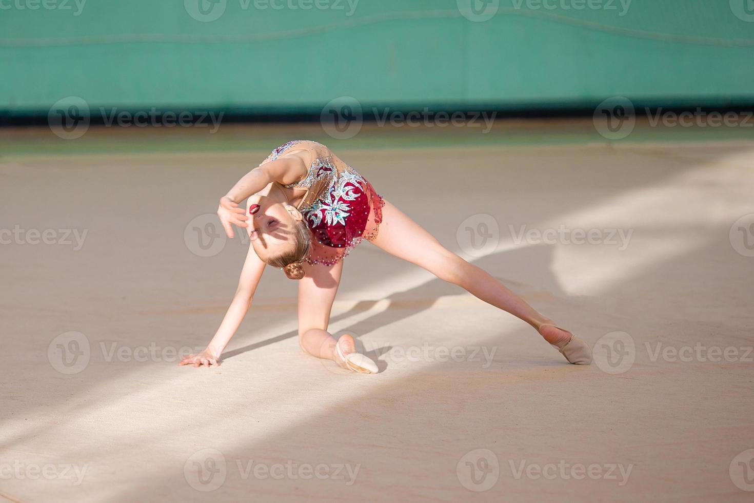 pequena ginasta treinando no tapete e pronta para competições foto